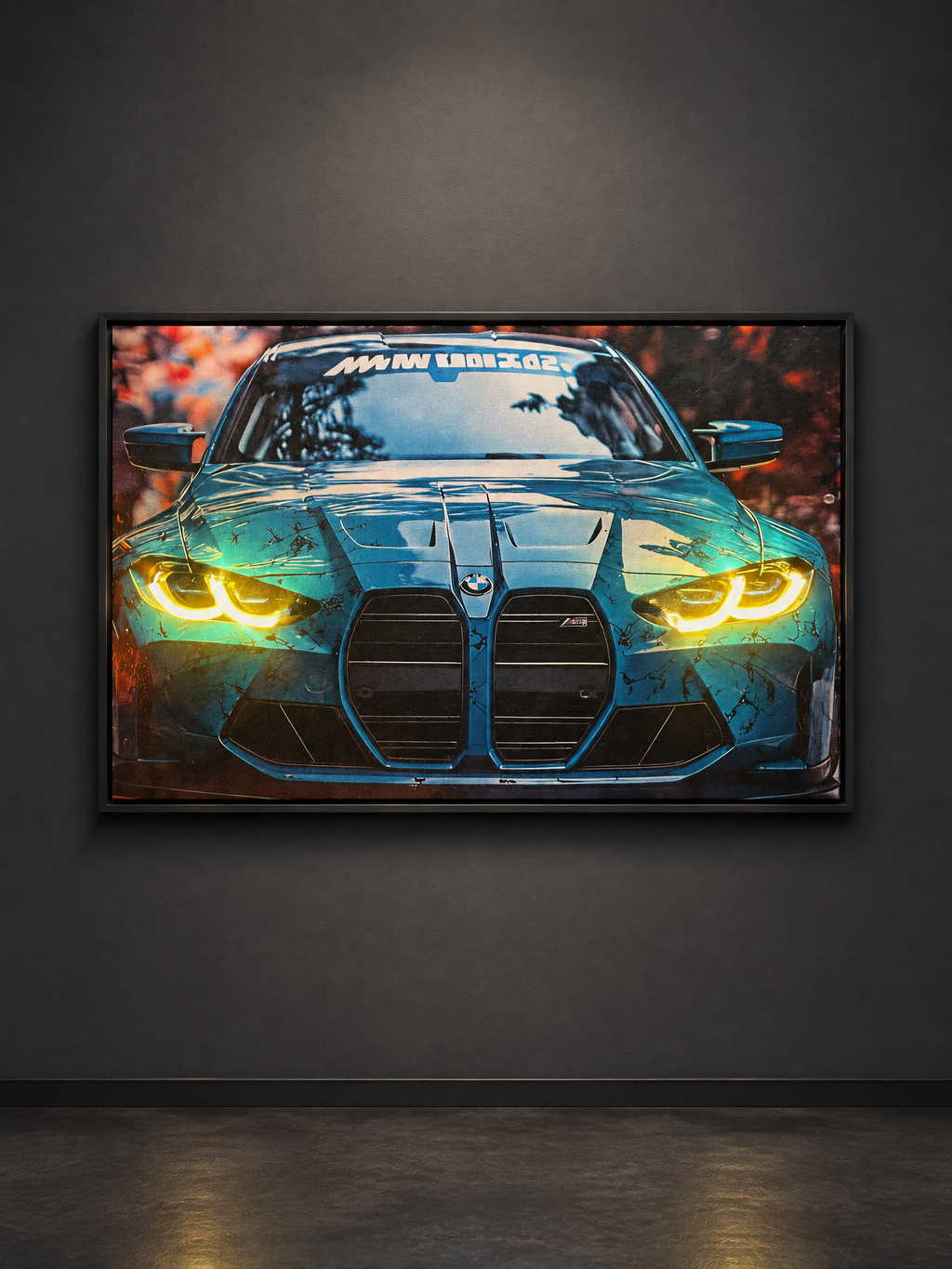 A framed automotive art print of a blue BMW M4 with glowing yellow headlights, displayed on a dark gray wall in a room setting.