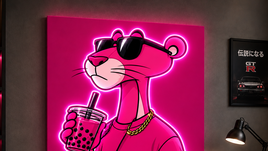 A large canvas wall art print featuring a neon pink cartoon panther wearing sunglasses and holding a boba drink, displayed in a modern gaming room with pink ambient lighting, shelves, a desk, and a chair.