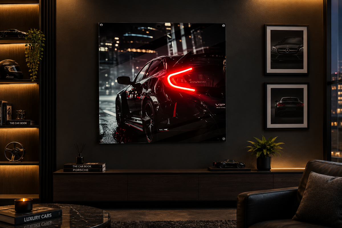 A large vertical wall art print showing a black sports car with a glowing red taillight in a city at night, displayed in a modern living room setting on a dark wall.
