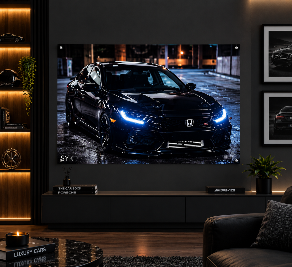 A large wall-mounted projection screen displays a black sports car on a wet city street at night. The room setting includes a dark wood console, framed wall art, a plant, and a sofa in a modern living room.