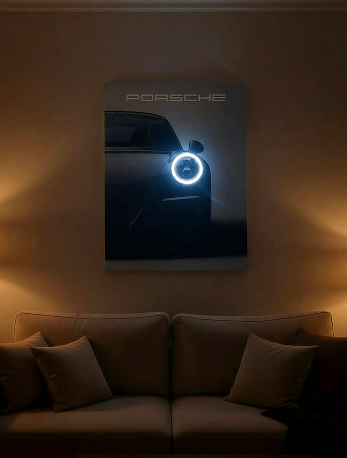 A framed Porsche car poster with a glowing blue ring light hangs on a warm brown wall above a beige sofa in a dimly lit living room.